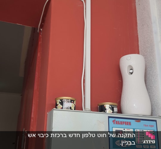 לוח בקרה של מערכת כיבוי אש על קיר אדום